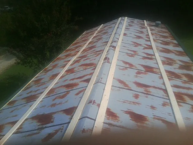 Rusted metal roof panels with new wood purlins before replacement — Storm Damage Roof Repair in Buffalo by Roofing Brothers